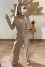 Mujer con conjunto de dos piezas, camiseta cruzada con detalle lateral y pantalón fluido, estilo casual elegante.