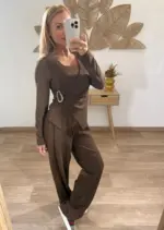 Mujer con conjutno de dos piezas, camiseta cruzada con detalle lateral y pantalón fluido, estilo casual elegante.