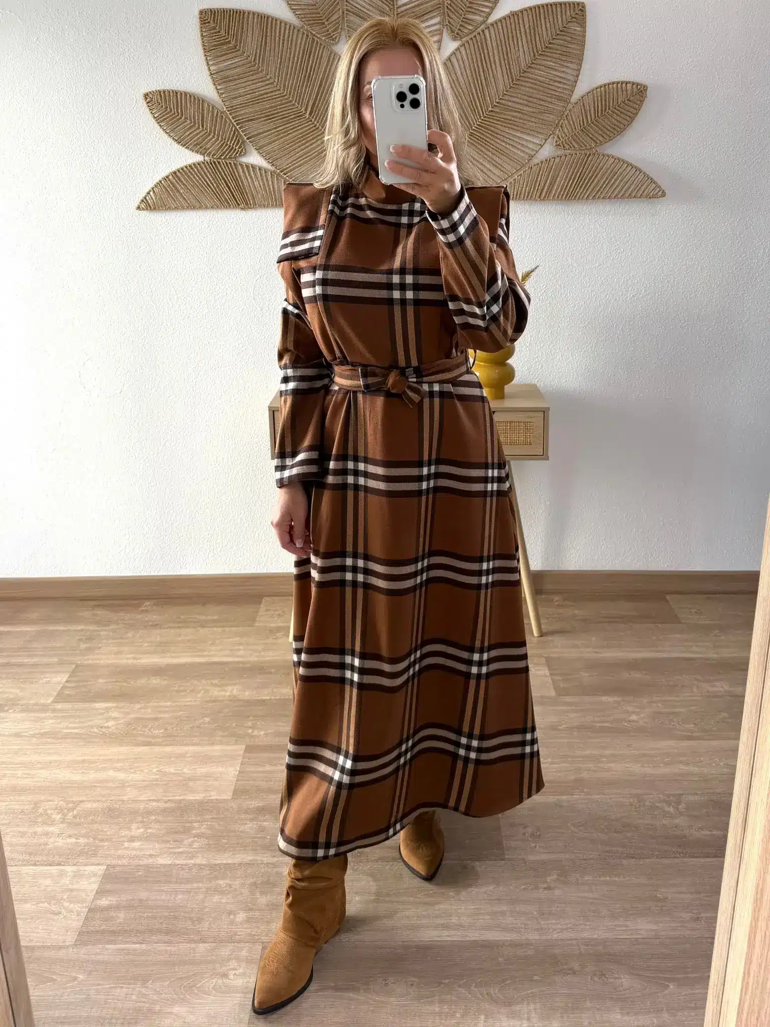 Vestido-largo-cuadros-1 Mujer con vestido largo de cuadros en tonos marrones y beige, de corte recto y cinturón a juego. Lleva botas de ante marrón claro con punta en forma de pico.