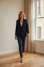 Americana sport azul marino entallada para mujer combinada con camiseta blanca y vaqueros ajustados.