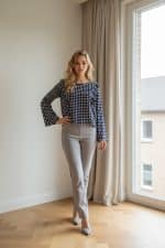 Blusa en color azul con estampado de lunares blancos, manga larga y corte recto.