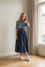 Camisa de mezclilla de manga larga para mujer con cierre de botones metálicos y dos bolsillos frontales con solapa.