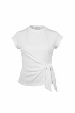 Camiseta marrón de manga corta con lazo lateral ajustable en el bajo, corte entallado, combinada con jeans ajustados.