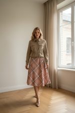 Chaqueta corta de ante rosa empolvado con cuello alto, bolsillos de parche y cintura ajustable mediante cordón.