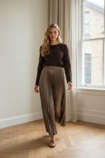 Falda midi plisada de color marrón con acabado satinado y caída fluida.