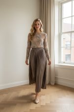 Falda midi plisada de color marrón con acabado satinado y caída fluida.