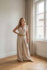 Pantalón fluido beige de tiro alto con pernera ancha, pinzas frontales y cinturón ancho a juego.